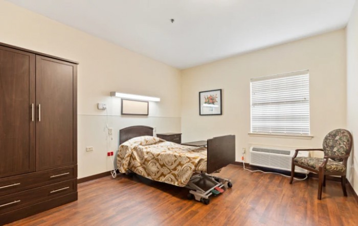 A simple hospital room with a single bed and minimalist decor.