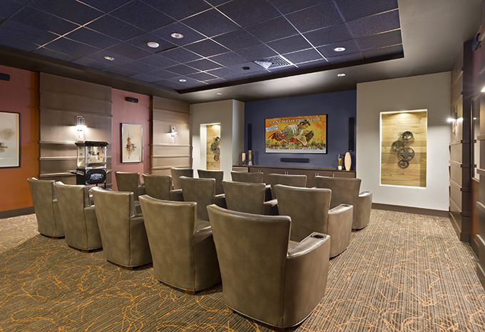 A modern theater room with comfortable seating and artwork on the walls.