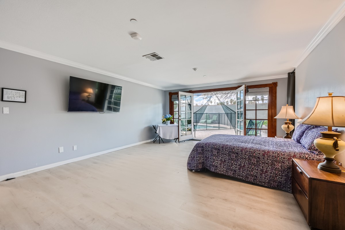 A spacious modern bedroom with large windows allowing natural light to fill the room.