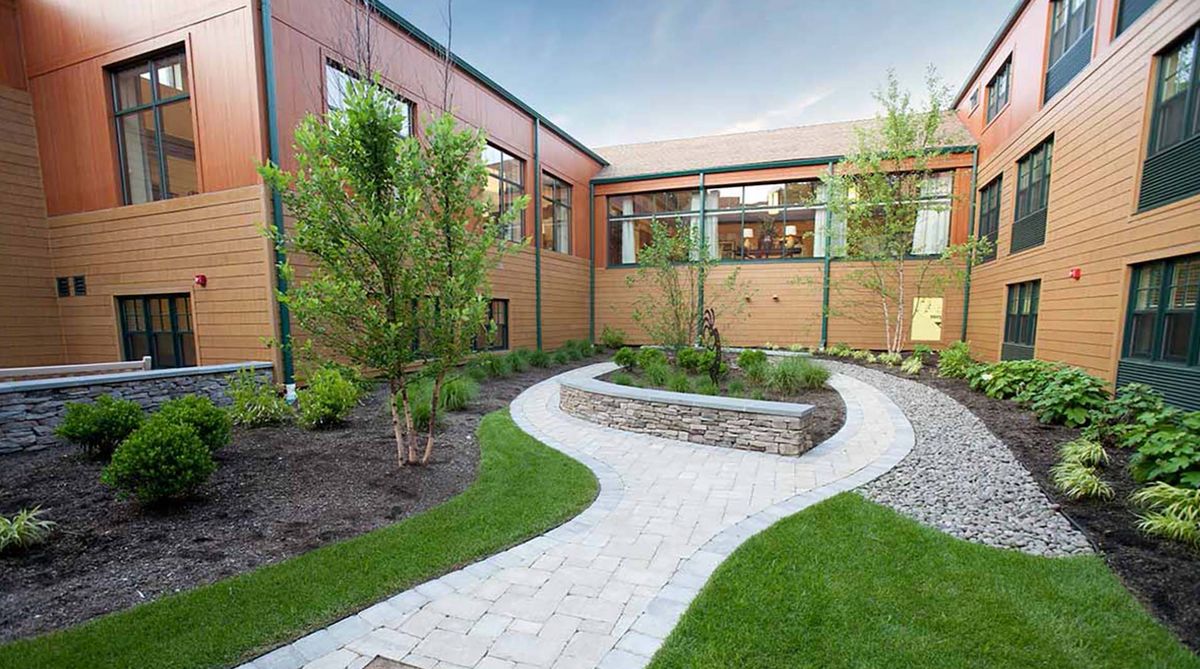A beautifully landscaped courtyard with a winding pathway and lush greenery.