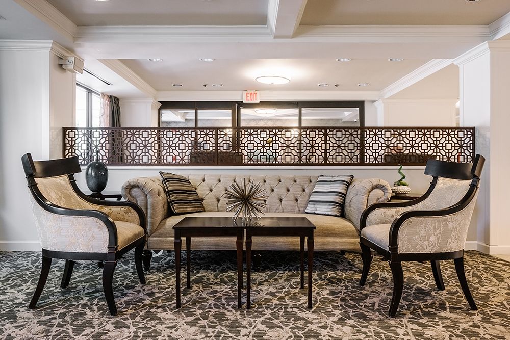 An elegant living room setting with a plush sofa, matching armchairs, and a central table, highlighted by decorative accents.