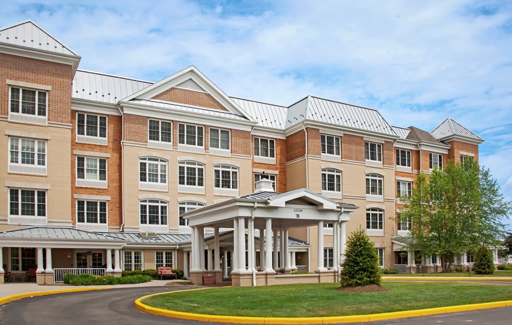 A four-story hotel building with a central entrance and well-maintained landscaping.