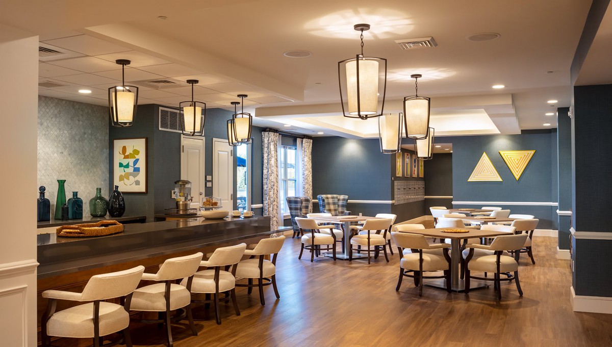 A well-lit restaurant interior featuring modern decor with neatly arranged tables and chairs.