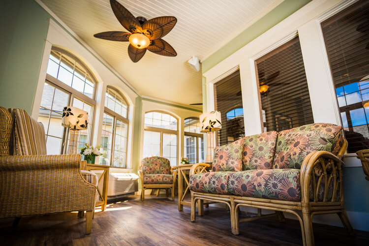A cozy sunroom with rattan furniture and abundant natural light.