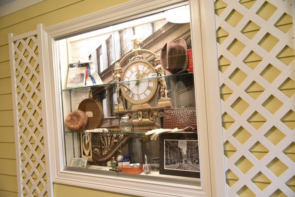 A display window showcasing an antique clock surrounded by vintage decor.