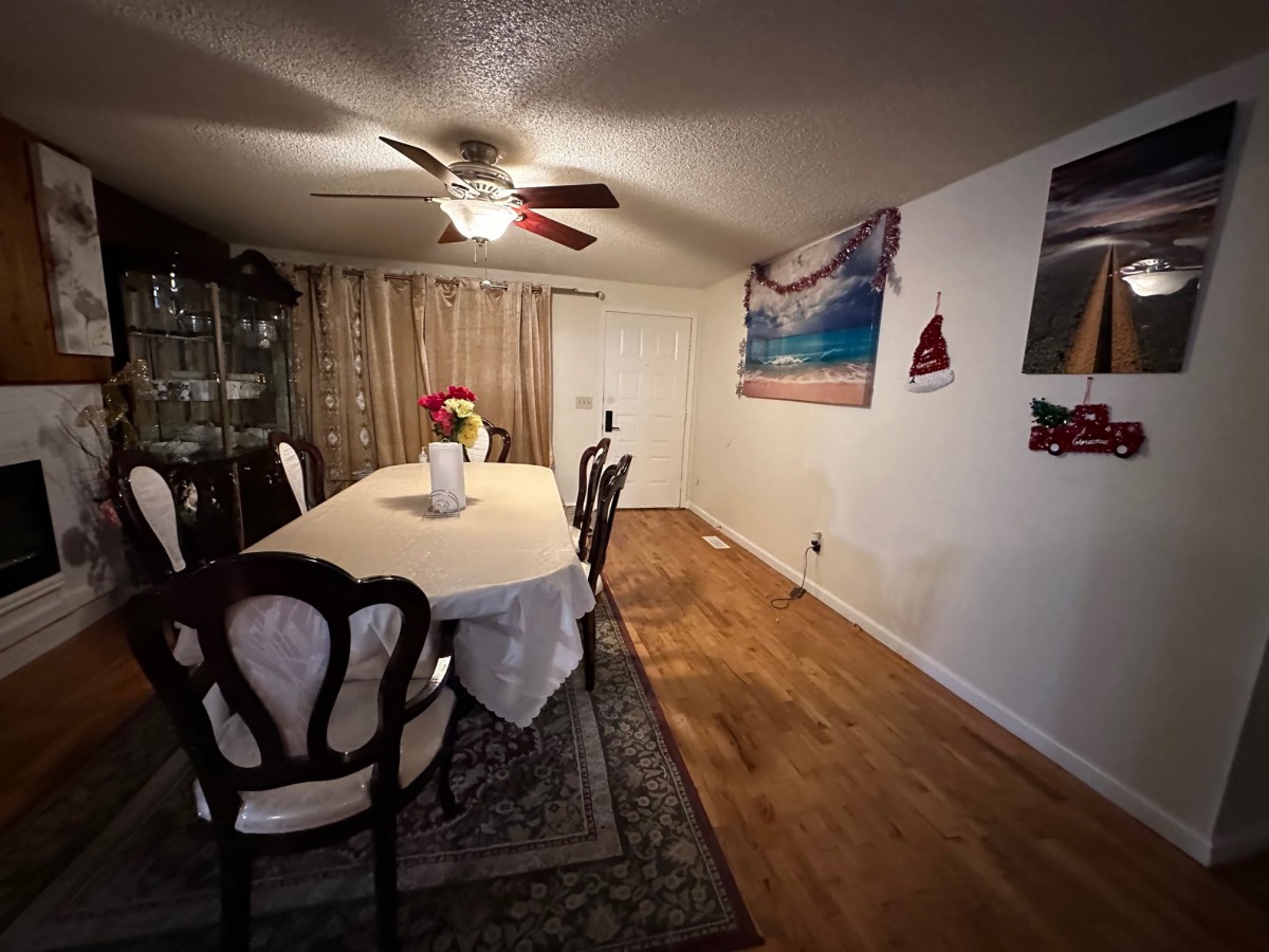 A cozy dining room with a long table, elegant chairs, and warm lighting.