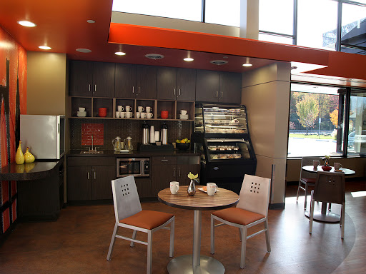 A cozy and modern caf space featuring a kitchenette with ample seating, highlighted by natural light.