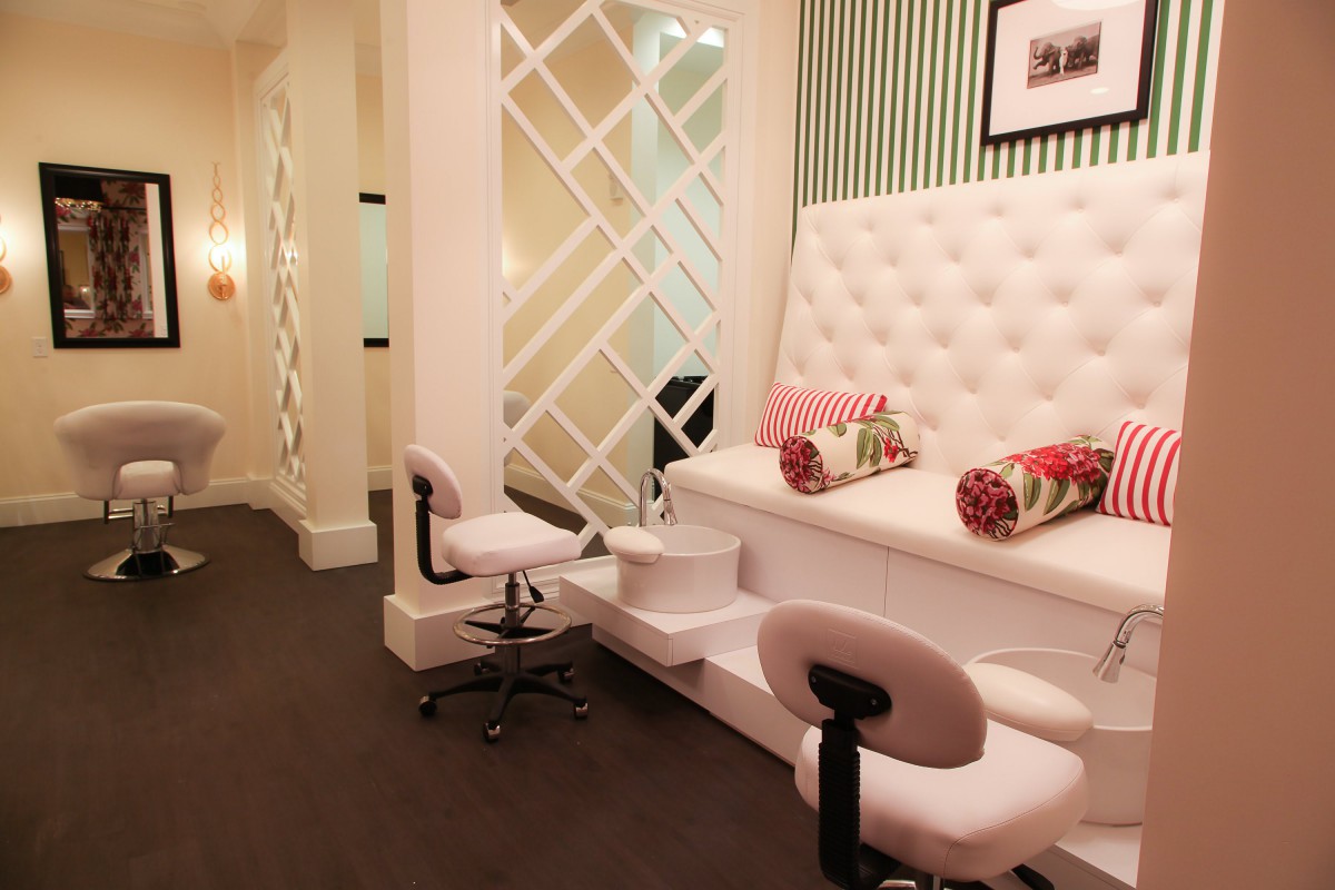 A modern and luxurious nail salon interior with white upholstered pedicure chairs and stylish decor.