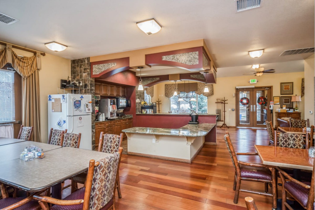 A spacious open-layout kitchen and dining area with modern design elements and wooden flooring.