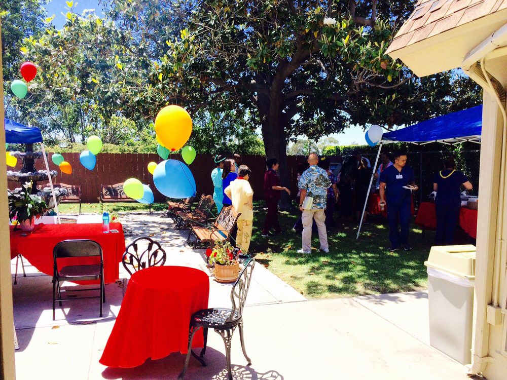 A colorful outdoor party with balloons and decorations in a garden setting.