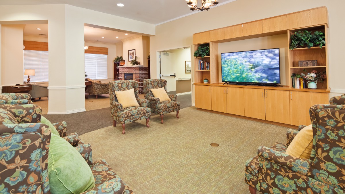 A cozy living room with comfortable chairs and a large television.