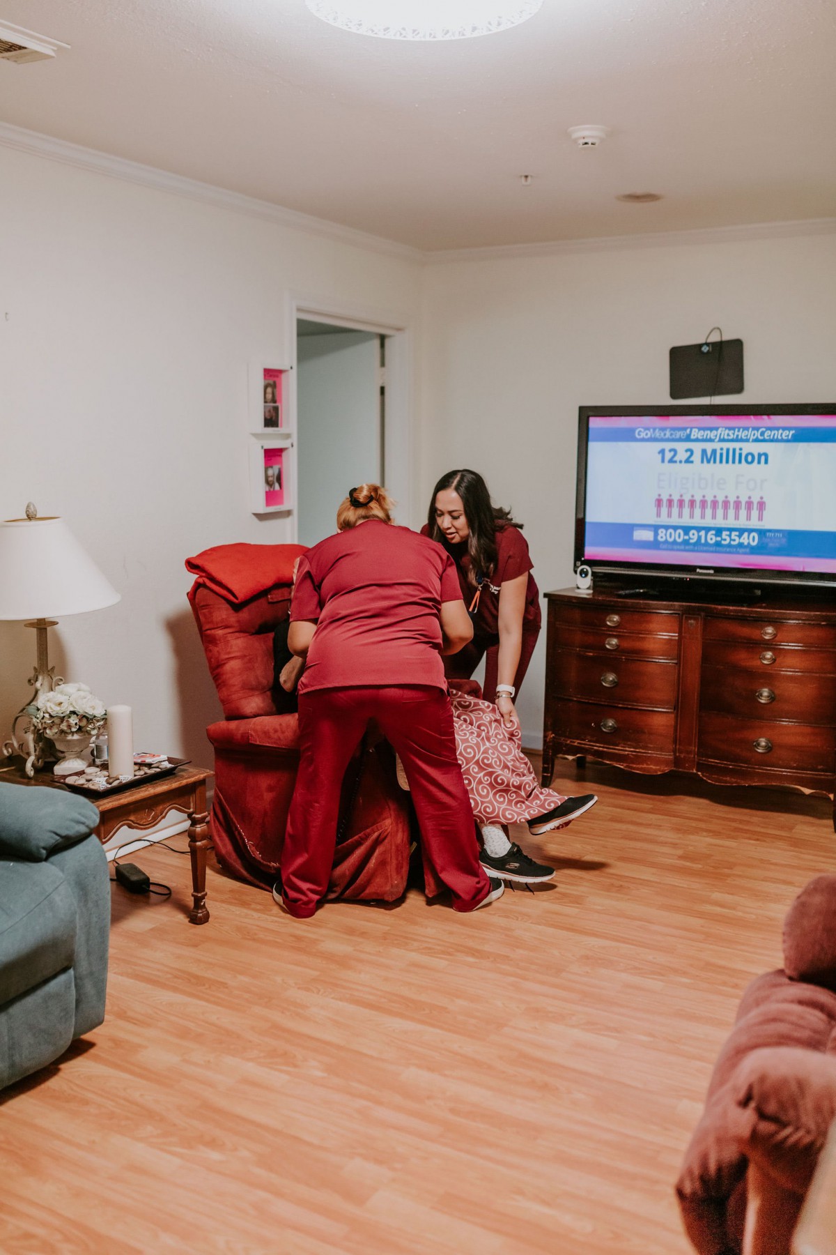 Caregivers assist a person in a home setting.