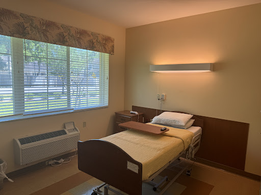 A well-lit hospital room featuring a single bed and a window allowing natural light.