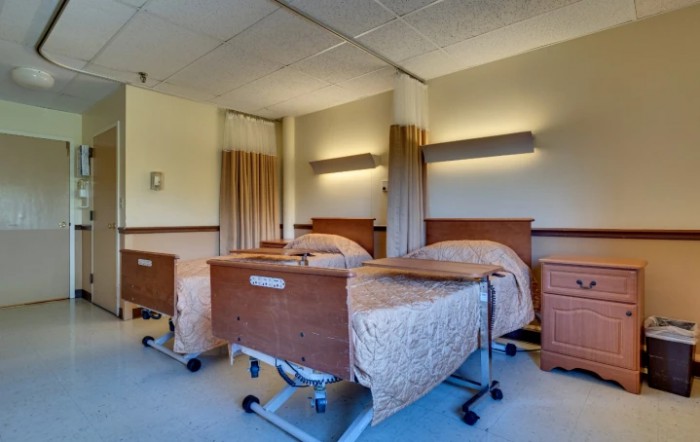 A hospital room with two patient beds, featuring a clean and organized medical environment.
