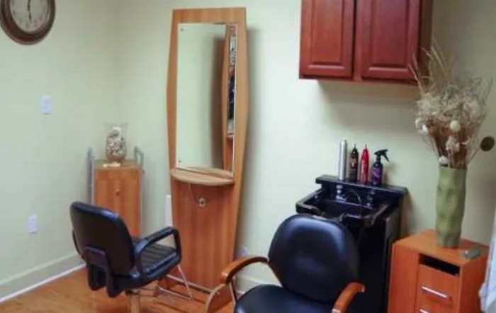 A cozy salon setup with chairs, a large mirror, and hair styling products.