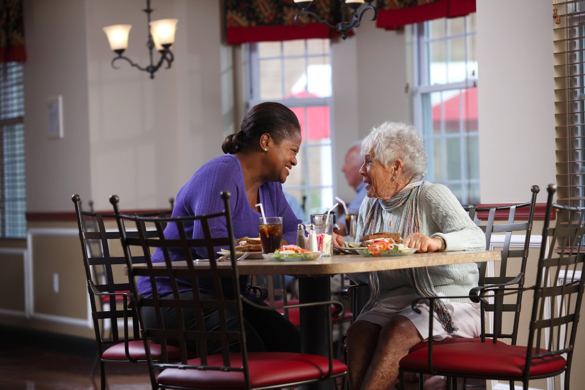 Two women enjoying a conversation over lunch in a restaurant.