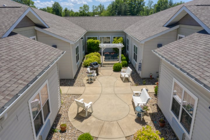 A spacious courtyard with outdoor seating and lush landscaping, featuring a pergola for added shade.