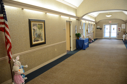A well-lit interior hallway featuring artwork on the walls and a welcoming atmosphere.