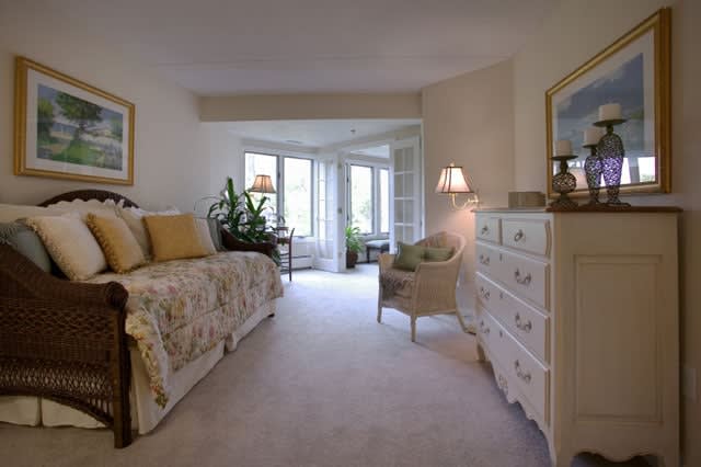 A cozy bedroom featuring bright natural light, elegant decor, and comfortable furnishings.