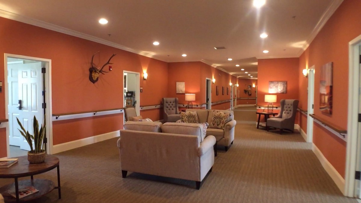 A cozy lounge area with orange walls, featuring comfortable sofas and warm lighting.
