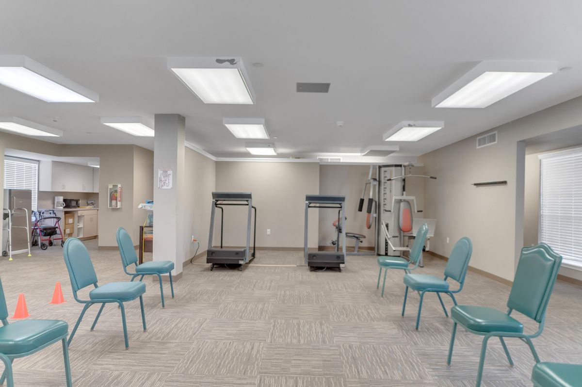 An indoor fitness area with treadmills and chairs arranged for a workout session.
