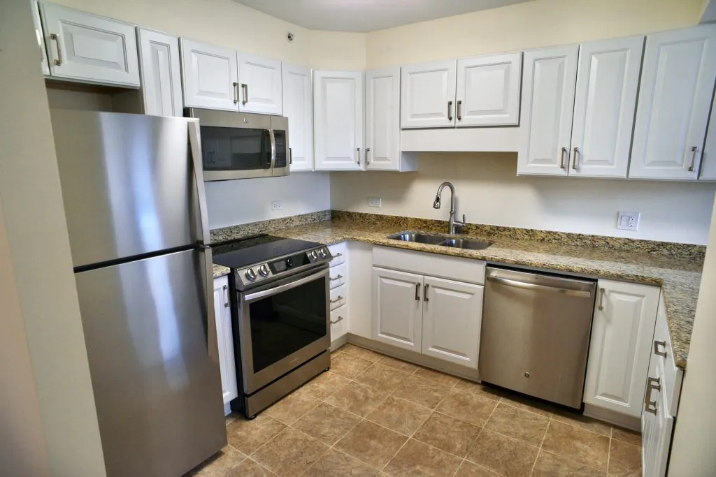A modern kitchen featuring stainless steel appliances and white cabinets.