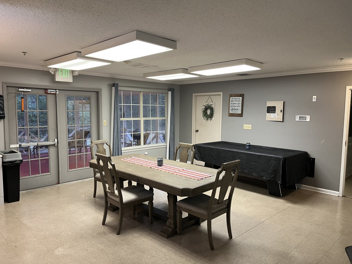 A cozy dining area with a pool table and ample lighting.