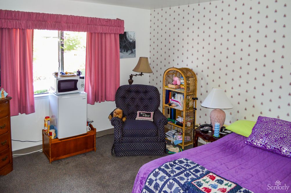A cozy living room with a comfortable armchair, a small bookshelf, and decorative elements.