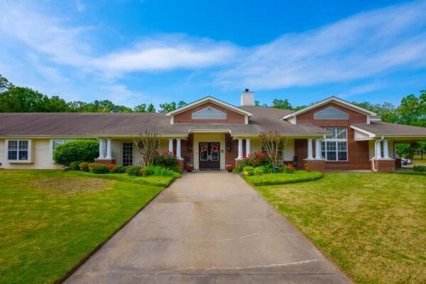 A single-story brick house with a driveway and well-maintained lawn.