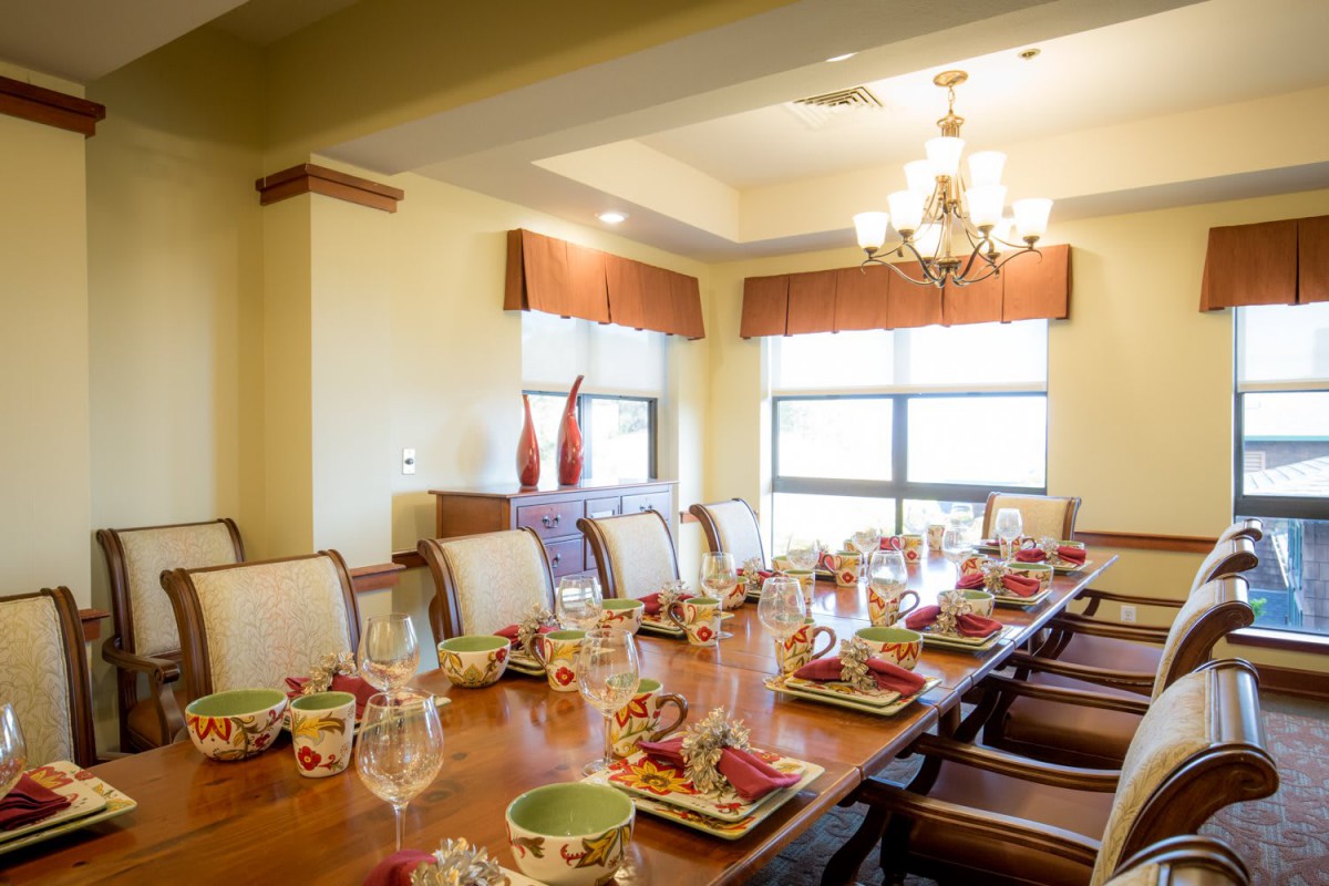 An elegant dining room with a beautifully set table and chandelier lighting.