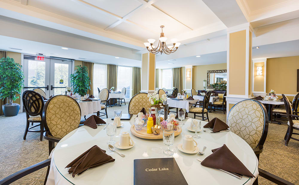 A beautifully set table in an elegant dining room with a chandelier.