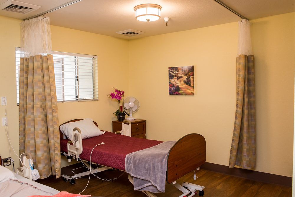 A well-lit hospital room with a bed and medical equipment.