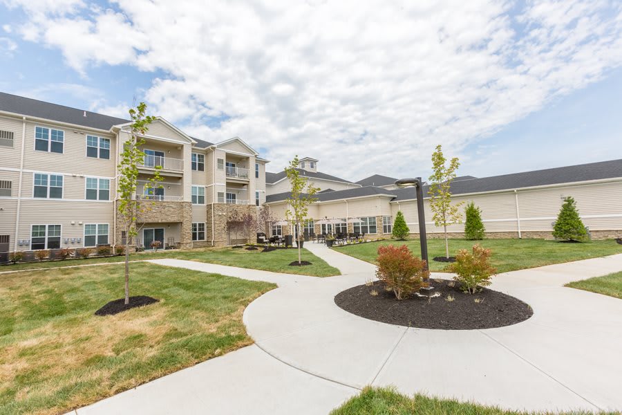 A modern apartment complex with well-maintained landscaping and paved pathways.