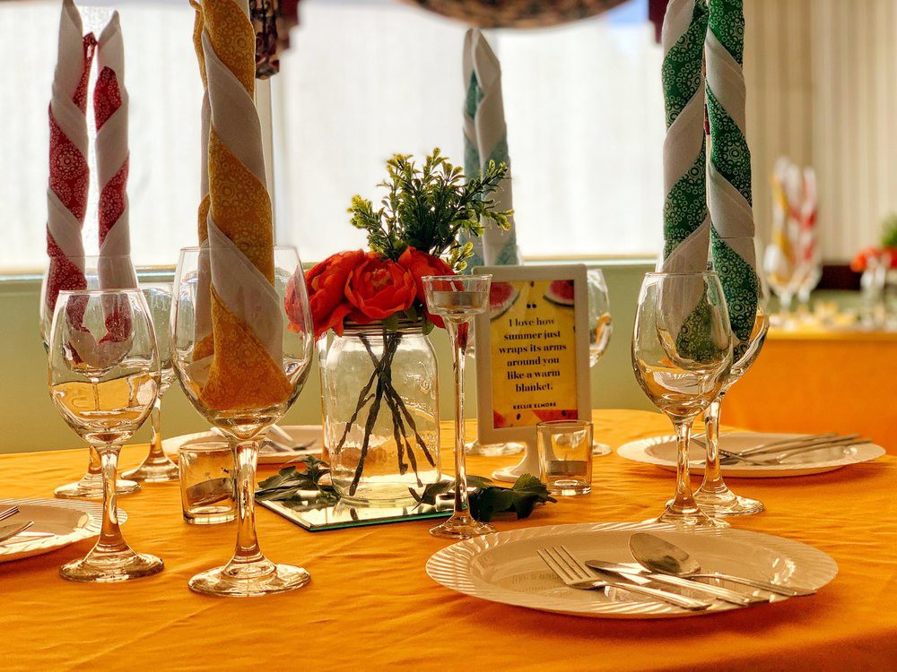 A beautifully arranged table with colorful napkins, elegant glassware, and a floral centerpiece.