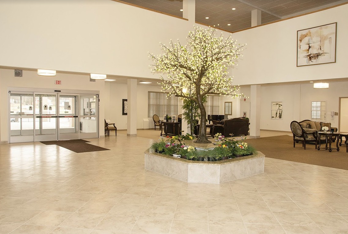 A spacious lobby with a decorative tree and seating area.