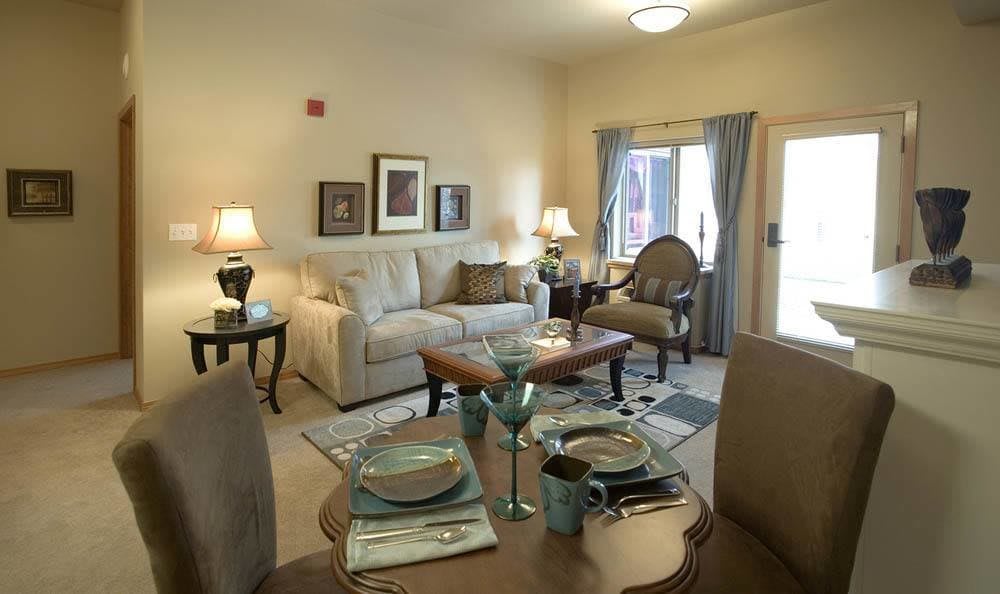 A cozy and elegantly decorated living room with a sofa, armchair, and dining setup.