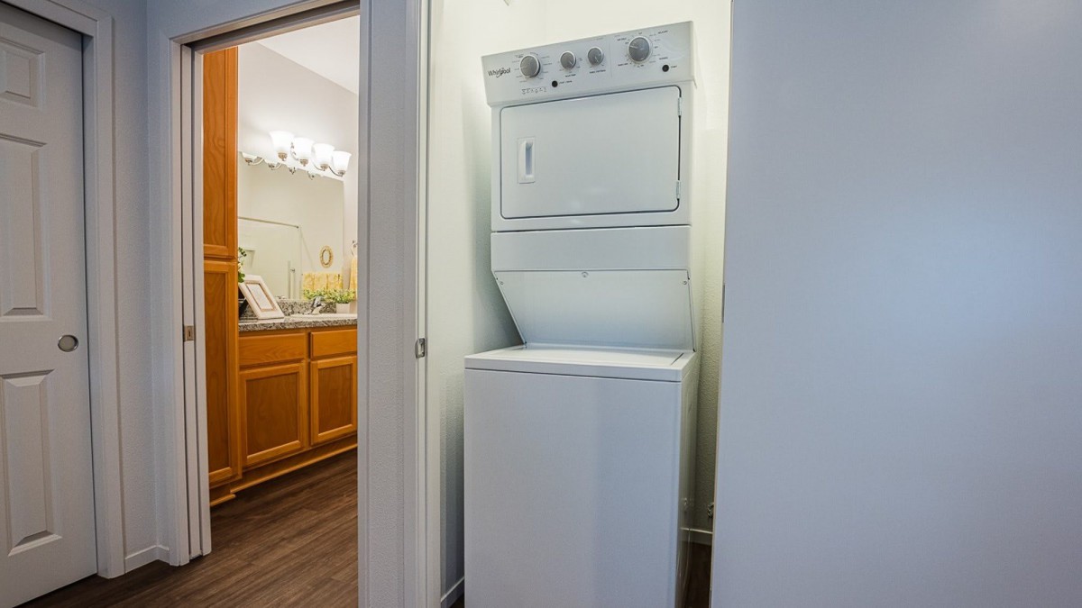 A compact laundry area featuring stacked washing and drying machines.