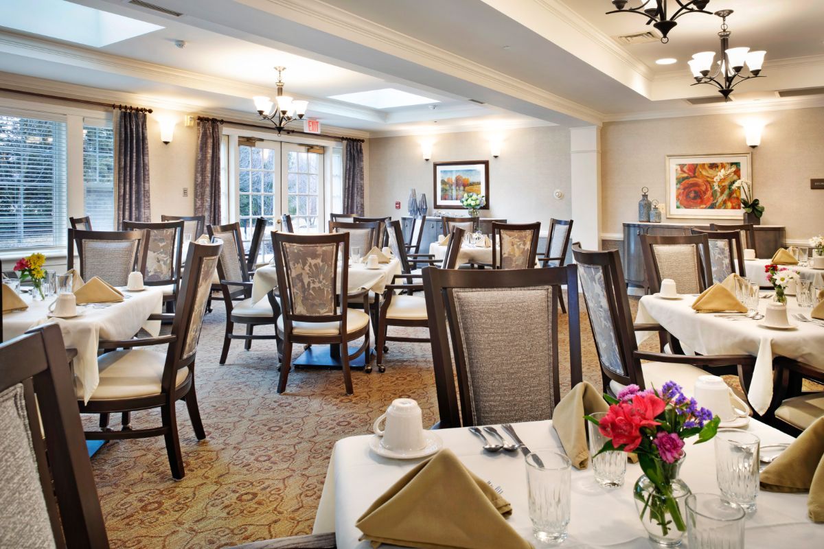 An elegant dining room with neatly arranged tables and chairs, featuring sophisticated decor and lighting.