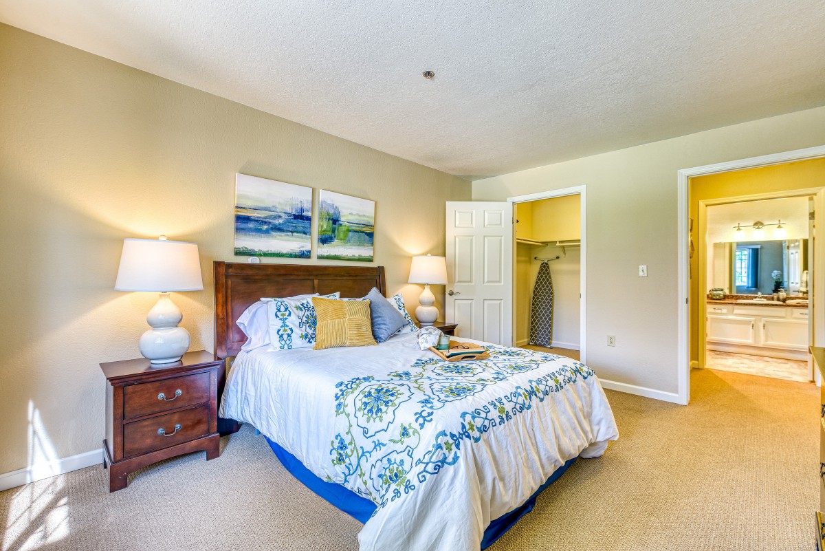 A cozy bedroom with a neatly made bed, decorative pillows, and bedside lamps adding warmth to the space.