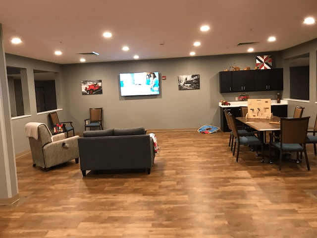 A modern living room with a sofa, television, and wooden flooring.