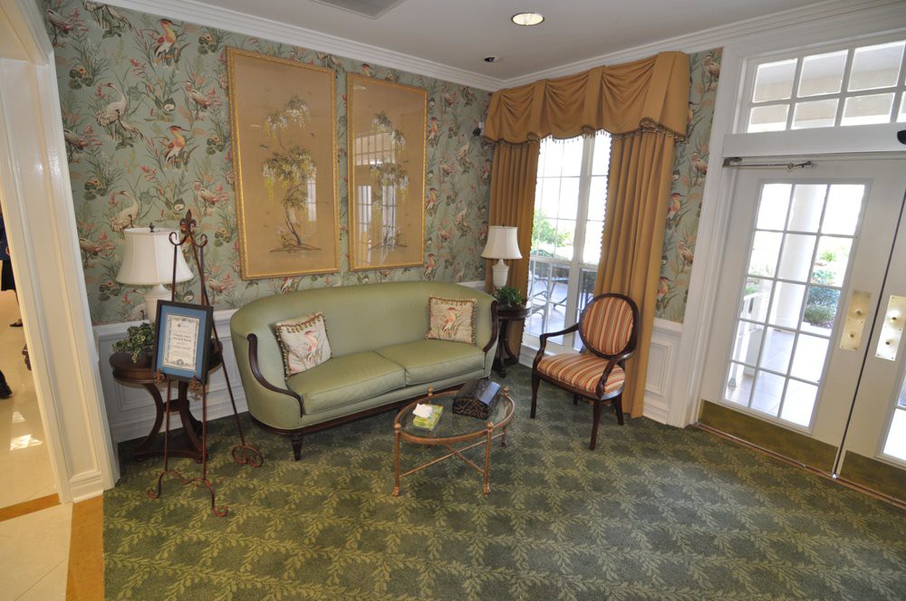 A vintage-style living room with a sofa, chair, and classic decor.