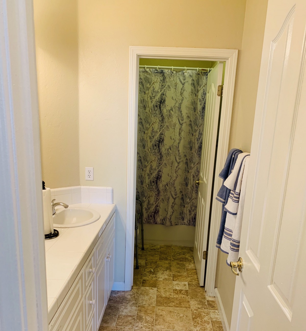 Compact bathroom with a sink and shower area.