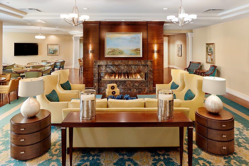 A cozy and elegant living room with a central fireplace, surrounded by plush seating and tasteful decor.