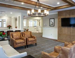 A modern living room featuring leather chairs, stylish lighting, and wood accents.