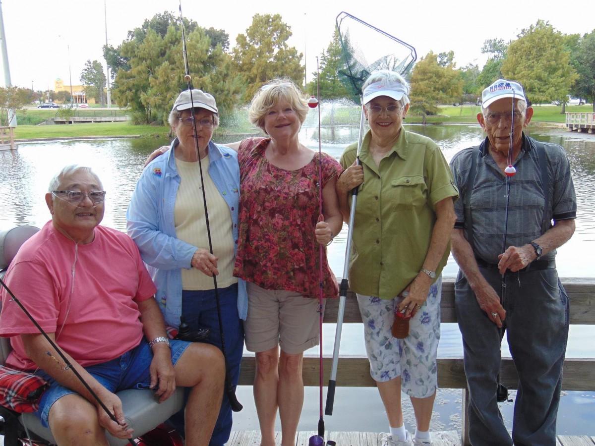 A group of people enjoying a day of fishing by the lake.