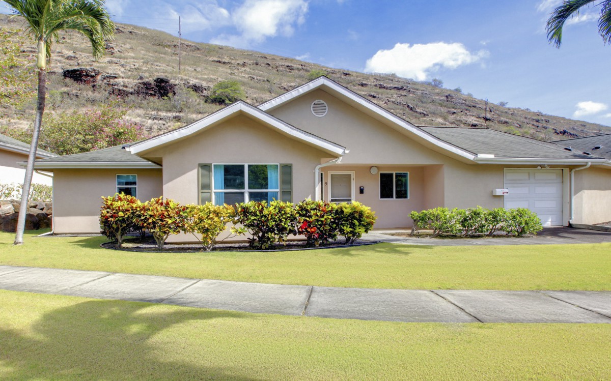A suburban house with a well-maintained yard on a sunny day.