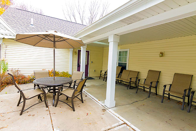 A cozy outdoor patio with seating and an umbrella, perfect for relaxation.