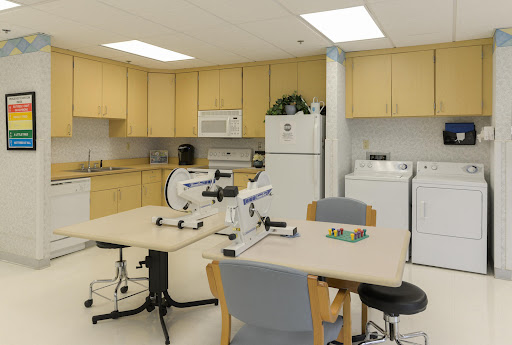 A well-equipped medical office featuring workstations with microscopes and a kitchenette area.