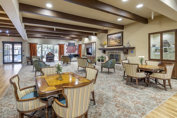 A spacious and elegantly decorated seating area with a fireplace and comfortable furniture.