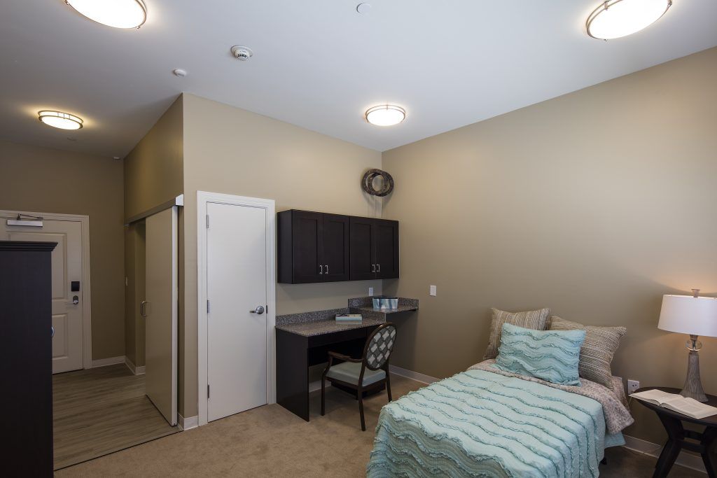 A modern bedroom with a single bed and a workspace.